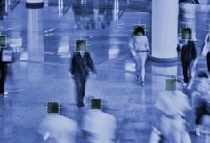 many people are walking through an airport lobby with blue and green squares on the floor