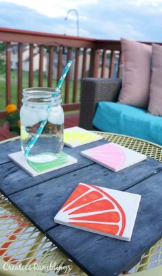 a mason jar filled with liquid sitting on top of a table next to some cards