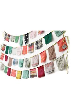 several pieces of fabric hanging from a line on the wall, each with different colors and patterns