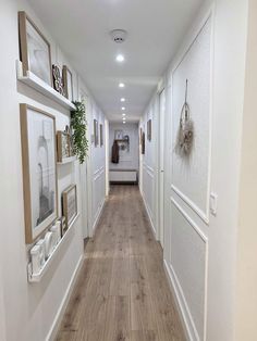 a long hallway with white walls and wooden floors