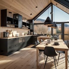 an open kitchen and dining area with wooden flooring, black cabinetry, and large windows