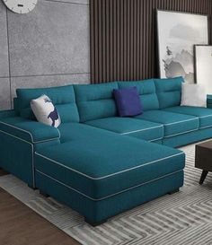 a living room with a blue sectional couch and coffee table in front of a clock