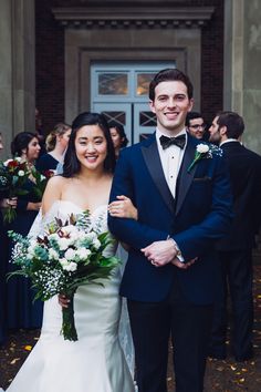 a bride and groom standing in front of a building