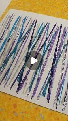 an art project is being made with colored pencils and paper on a yellow surface