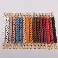 a bunch of different colored leather bracelets with gold clasps on each one side