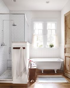 a bathroom with a bathtub, sink and window