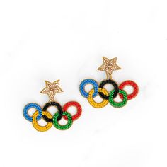 two pairs of earrings with stars and rings on top of each other in different colors