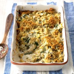 a casserole dish with broccoli and cheese in it next to a spoon