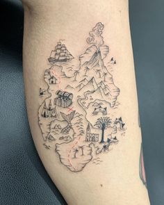 a person with a tattoo on their leg that has an image of mountains and houses