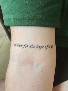 a person with a tattoo on their arm that says to live for the hope of it all