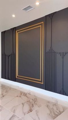 an empty room with marble flooring and walls painted in black, gold and white