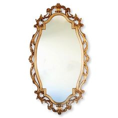 an ornate gold framed mirror on a white wall