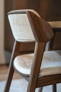 a close up of a wooden chair with fabric on the seat and backrests