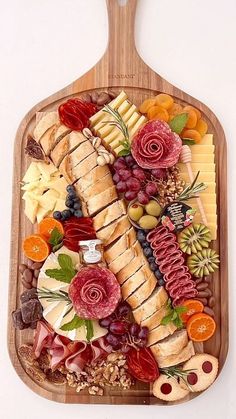 a wooden platter filled with lots of different types of cheeses and meats