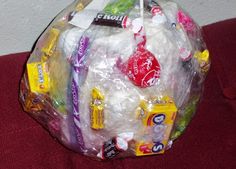 a basket filled with candy and candies on top of a red couch next to a wall