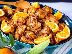 a blue bowl filled with chicken and oranges