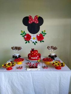 a table topped with lots of food next to a mickey mouse wall hanging on the wall