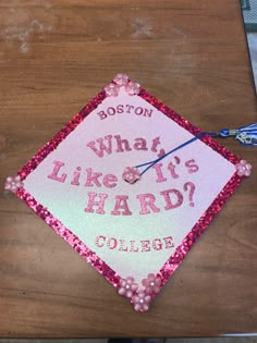 a pink graduation cap that says boston what like it's hard?