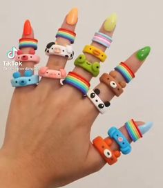 a hand with many different colored rings on it's fingers and one is holding the other