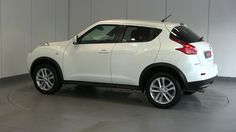 a white nissan juke is parked in a garage