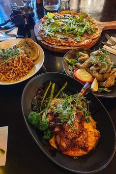 several plates of food on a table with utensils