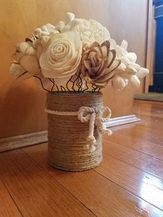 a vase filled with white flowers on top of a wooden floor