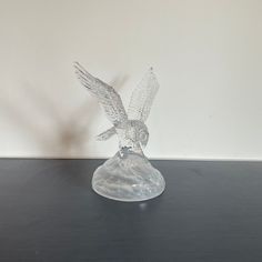 a clear glass bird on a black table