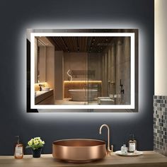 a bathroom with a sink, mirror and bathtub in the middle is illuminated by lights