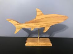 a wooden sculpture of a shark on a stand