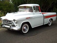 an old white truck is parked on the street