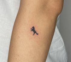 a small black horse tattoo on the left arm and right arm, it appears to be an animal that is running