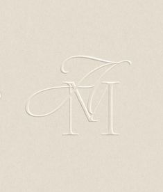 the letter m is made out of white paper and has a monogrammed design on it