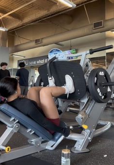 a woman sitting on top of a bench in a gym