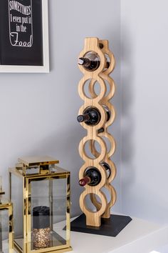 a wooden wine rack sitting on top of a white table next to a glass case