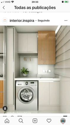 an image of a washing machine in a small room with white cabinets and wood accents