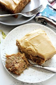 two pieces of cake sitting on top of a white plate next to forks and knives