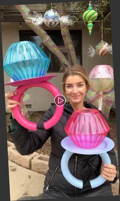 a woman is holding up some colorful objects