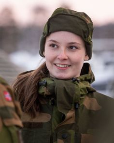 a woman in camouflage is smiling for the camera