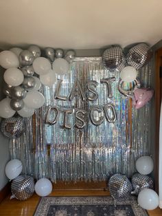 balloons and streamers decorate the entrance to a disco themed birthday party with silver foil