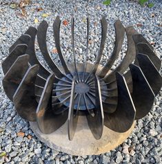 a metal sculpture sitting on top of a gravel field