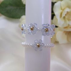 a close up of a ring on a table with flowers in the backgroud