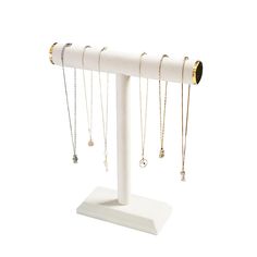 a white display stand with several necklaces on it