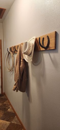 a hat and cowboy hats are hanging on the wall next to a pair of horseshoes