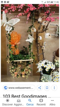 flowers and butterflies are hanging on the wall next to a planter filled with white daisies