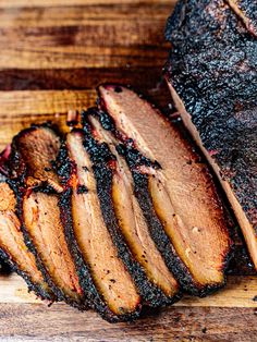 sliced meat sitting on top of a wooden cutting board