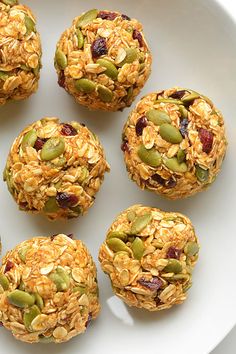 a white plate topped with granola balls covered in nuts