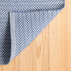 a blue and white rug on top of a wooden floor next to a wood floor