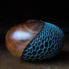 a close up of an object on a wooden surface with blue and brown patterns around it