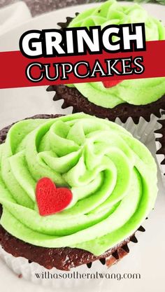 two cupcakes with green frosting and a red heart on top are shown