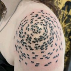 a woman's arm with many small black bugs on the back of her shoulder